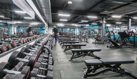 Gym showing weights, benches and equipment in he background.
