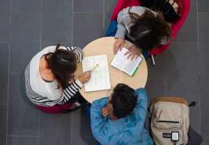 Birds eye view image of three students at a desk 
